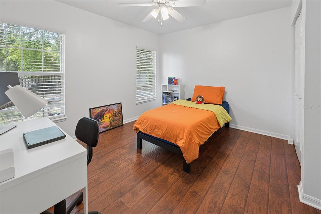 6924 Southwest 80th Drive Gainesville, FL 32608 - Photo 40 of 65 a bedroom with a bed and a chandelier