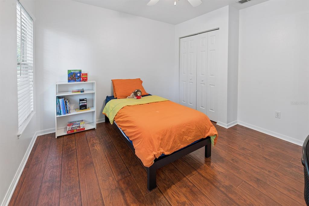 6924 Southwest 80th Drive Gainesville, FL 32608 - Photo 41 of 65 a bedroom with a bed and wooden floor