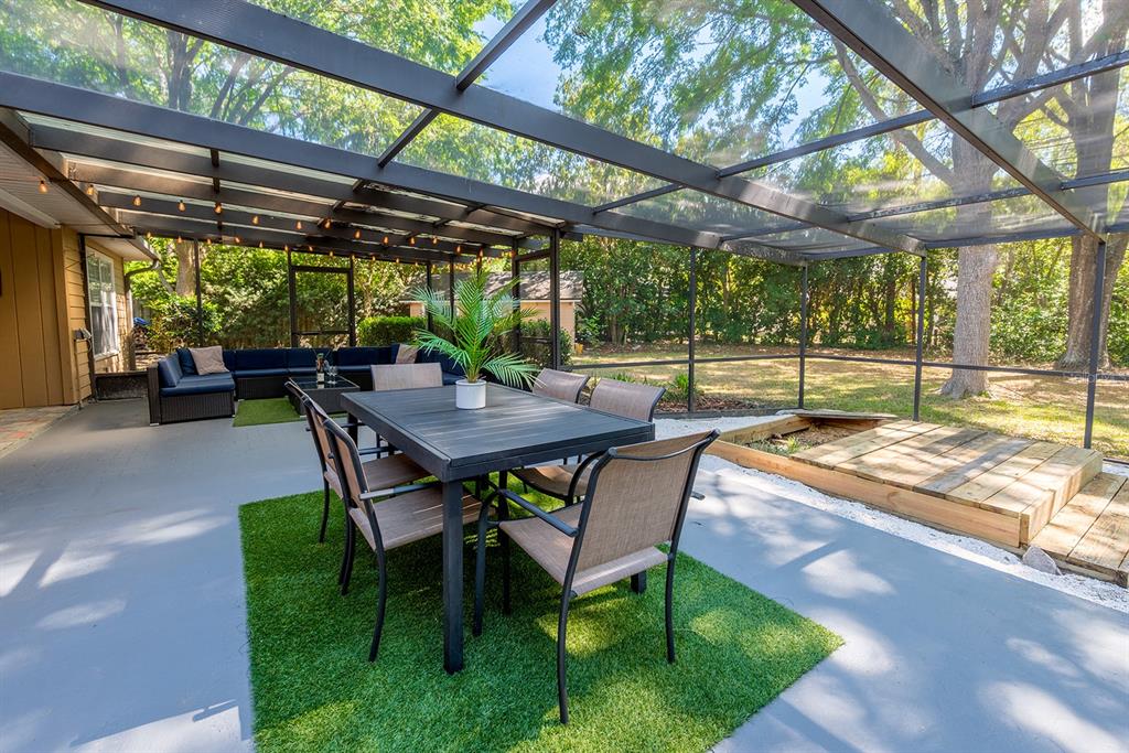 6924 Southwest 80th Drive Gainesville, FL 32608 - Photo 48 of 65 a view of patio with a table and chairs under a large umbrella