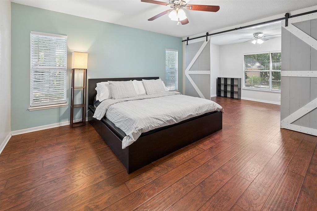 6924 Southwest 80th Drive Gainesville, FL 32608 - Photo 8 of 65 a spacious bedroom with a bed and a chandelier