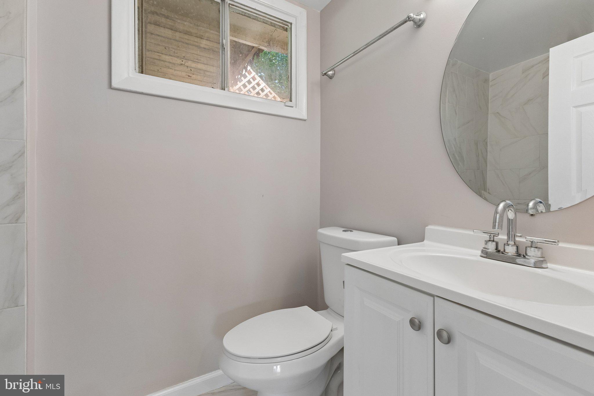 14197 Fullerton Road Woodbridge, VA 22193 - Photo 10 of 23 a bathroom with a toilet a sink and mirror