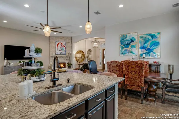 a kitchen with granite countertop a sink a counter top space and living room view