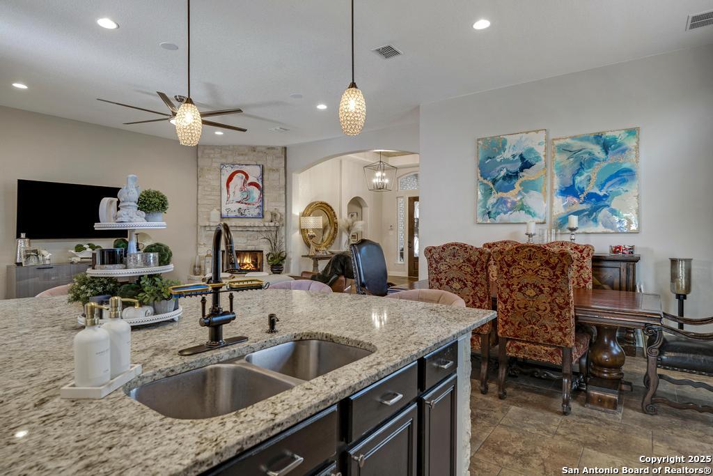 13326 Windmill Trace Helotes, TX 78023 - Photo 14 of 34 a kitchen with granite countertop a sink a counter top space and living room view