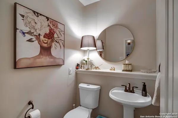 a bathroom with a toilet sink and mirror