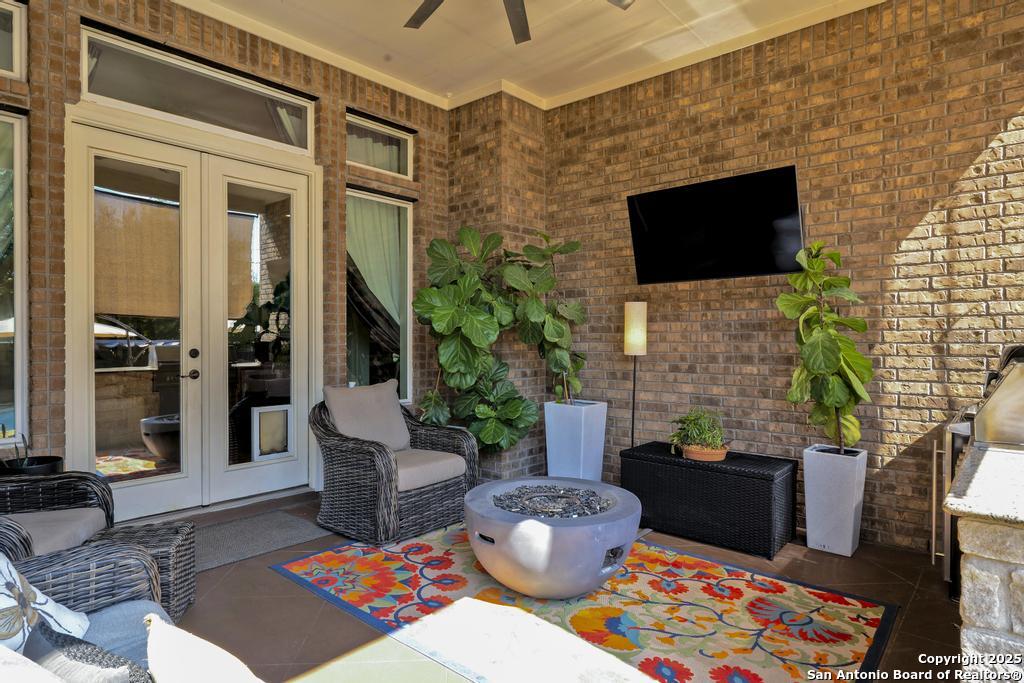 13326 Windmill Trace Helotes, TX 78023 - Photo 30 of 34 a living room with patio furniture and a flat screen tv