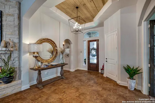 a living room with furniture a potted plant and a chandelier
