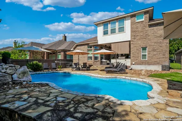 a view of a house with swimming pool and sitting area