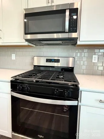 a stove top oven sitting inside of a kitchen