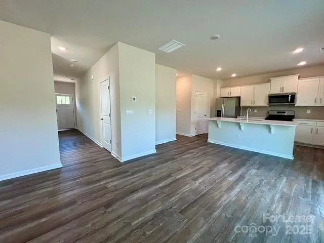 a view of kitchen with wooden floor and electronic appliances