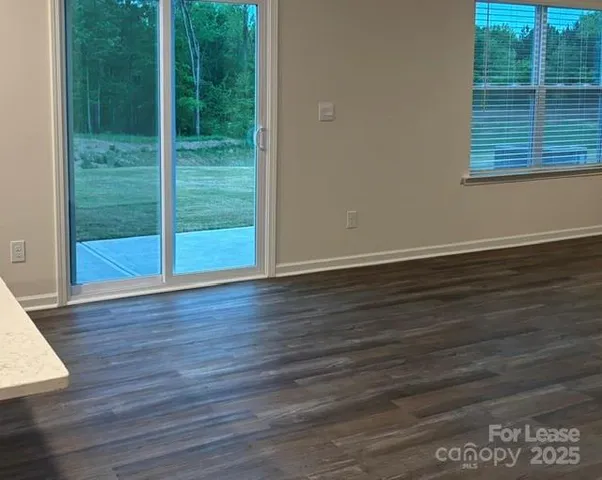 a view of a room with wooden floor and windows