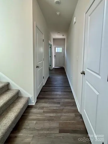 a view of a hallway with wooden floor and staircase
