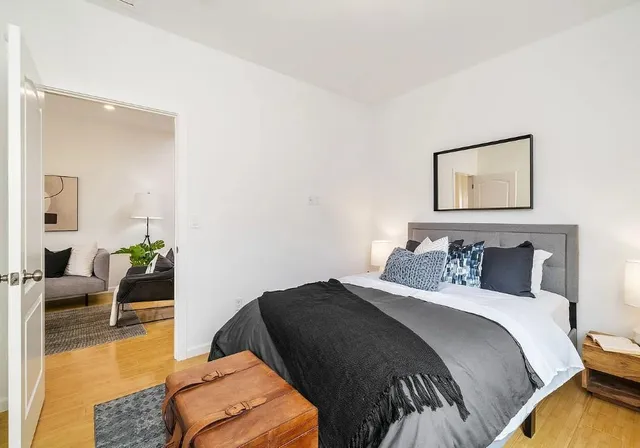 a bedroom with a bed and wooden floor