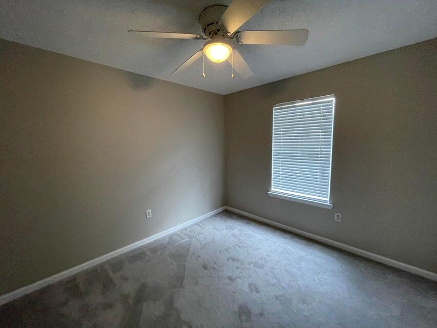 487 Woodlawn Road Freeport, FL 32439 - Photo 12 of 15 an empty room with a chandelier fan and windows