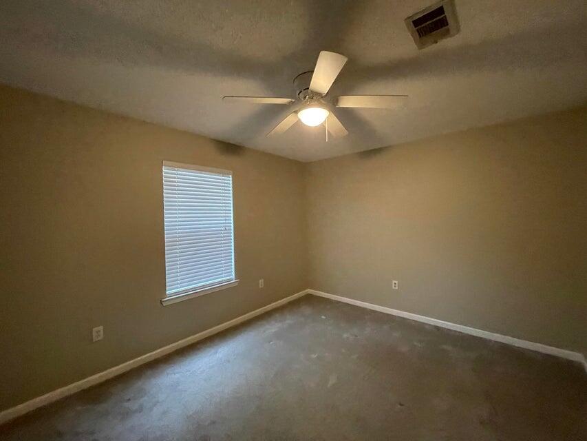 487 Woodlawn Road Freeport, FL 32439 - Photo 9 of 15 an empty room with a chandelier fan and windows