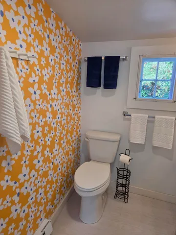 a white toilet sitting next to a shower curtain