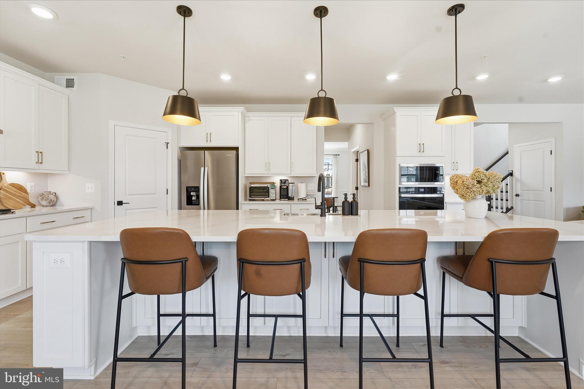 910 Enfield Farm Lane Brunswick, MD 21716 - Photo 14 of 87 a kitchen with stainless steel appliances kitchen island granite countertop a table chairs and white cabinets
