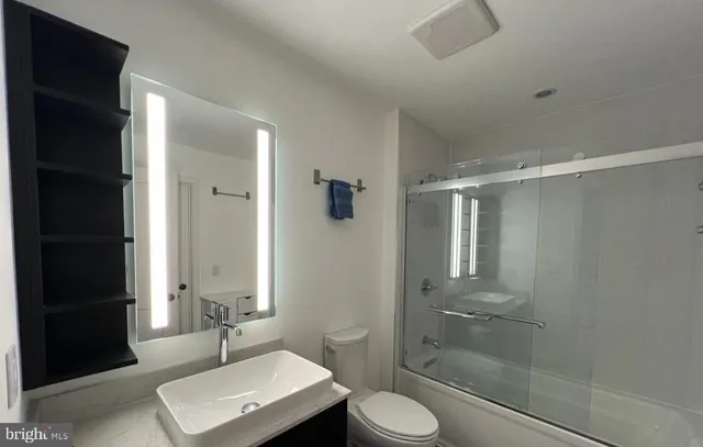 a bathroom with a shower a sink and toilet