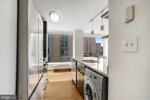 a kitchen with stainless steel appliances kitchen island granite countertop a table chairs in it and wooden floors