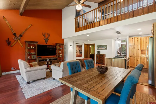a living room with furniture a flat screen tv and kitchen view