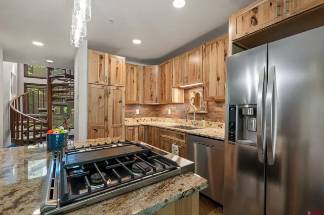 a kitchen with stainless steel appliances granite countertop a stove refrigerator and cabinets