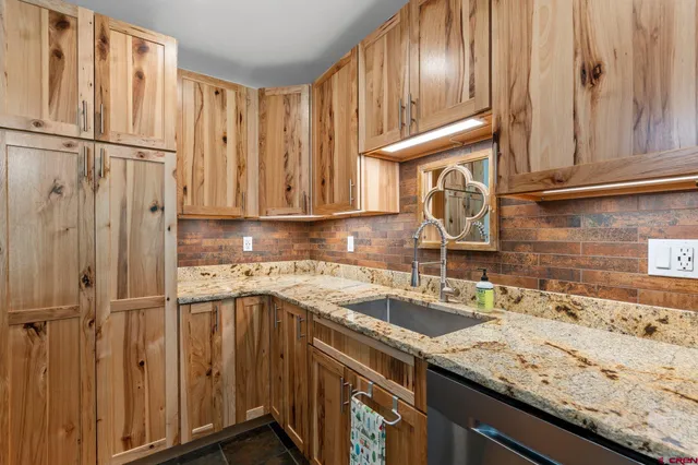 a kitchen with granite countertop stainless steel appliances a sink and cabinets