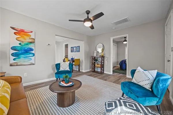 a living room with furniture and a wooden floor