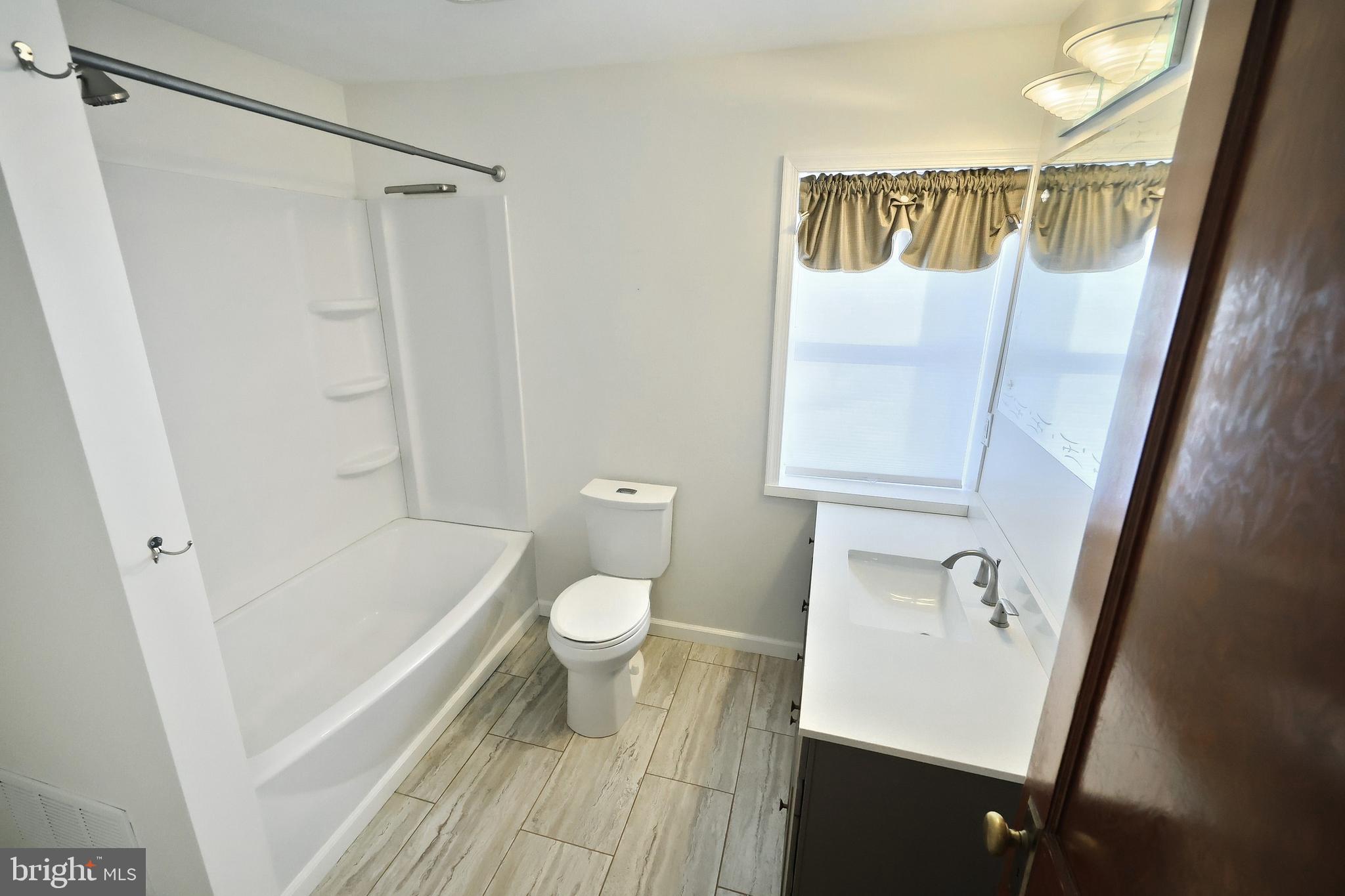 6691 Harmony Grove Road Dover, PA 17315 - Photo 40 of 66 a bathroom with a sink a toilet a mirror and shower
