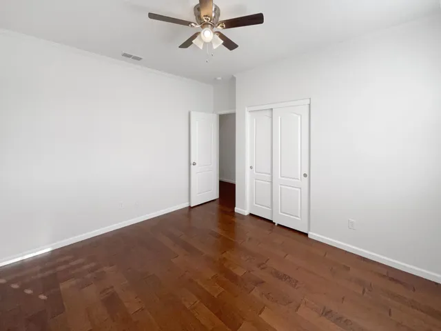 an empty room with a ceiling fan and window