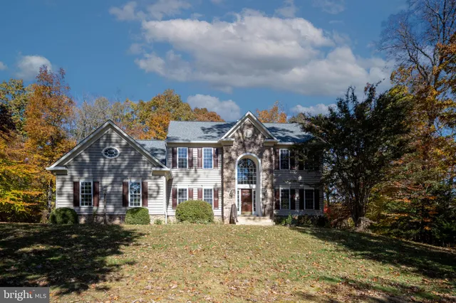 a view of a house in a yard with wooden fence