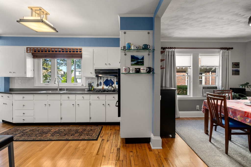 15 Berkshire Road, Unit 1 Waltham, MA 02453 - Photo 18 of 42 a kitchen with granite countertop white cabinets and wooden floor