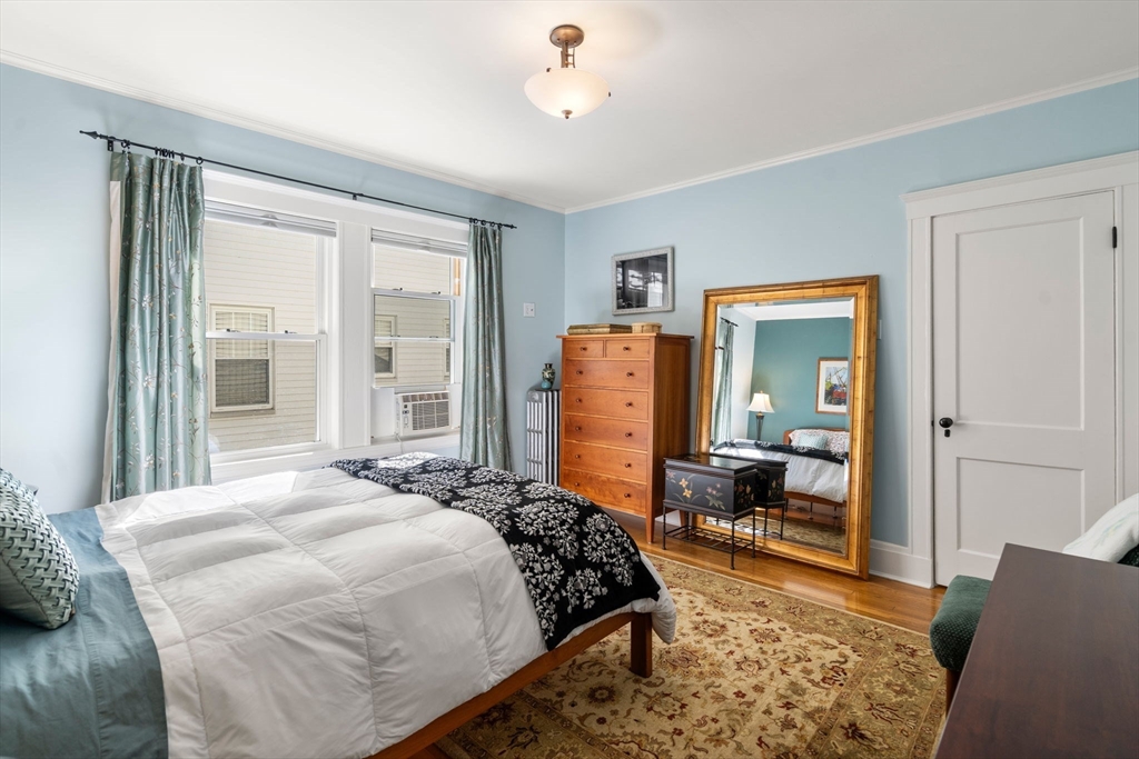 15 Berkshire Road, Unit 1 Waltham, MA 02453 - Photo 26 of 42 a bedroom with a bed and wooden floor