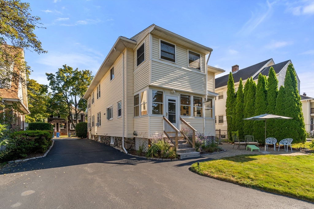 15 Berkshire Road, Unit 1 Waltham, MA 02453 - Photo 4 of 42 a front view of a house with yard and outdoor seating