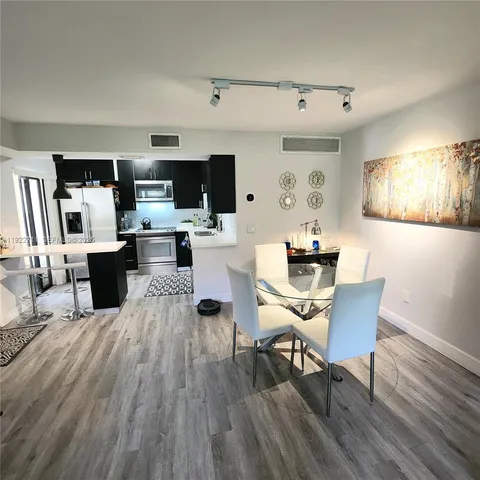 a living room with furniture a flat screen tv and kitchen view