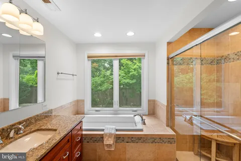 a spacious bathroom with a granite countertop tub and a large window