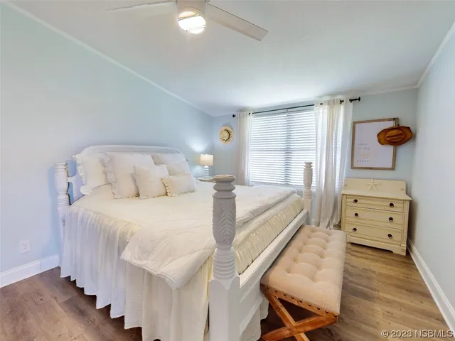 a spacious bedroom with a bed and wooden floor