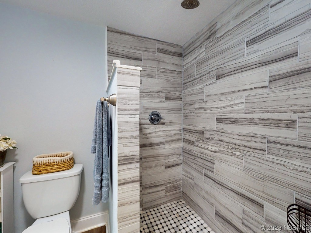 69 Sabal Cay Court, Unit 690 New Smyrna Beach, FL 32169 - Photo 14 of 30 a bathroom with a toilet and a shower