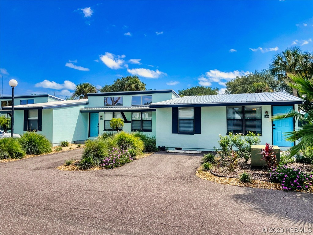 69 Sabal Cay Court, Unit 690 New Smyrna Beach, FL 32169 - Photo 2 of 30 a front view of a house with garden
