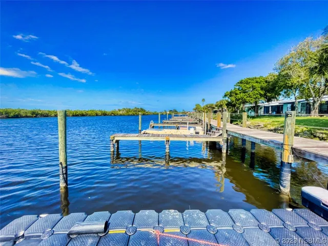 a view of a rooftop deck with chairs and wooden fence