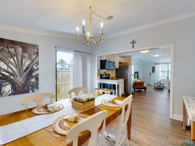a living room with furniture kitchen view and a large window