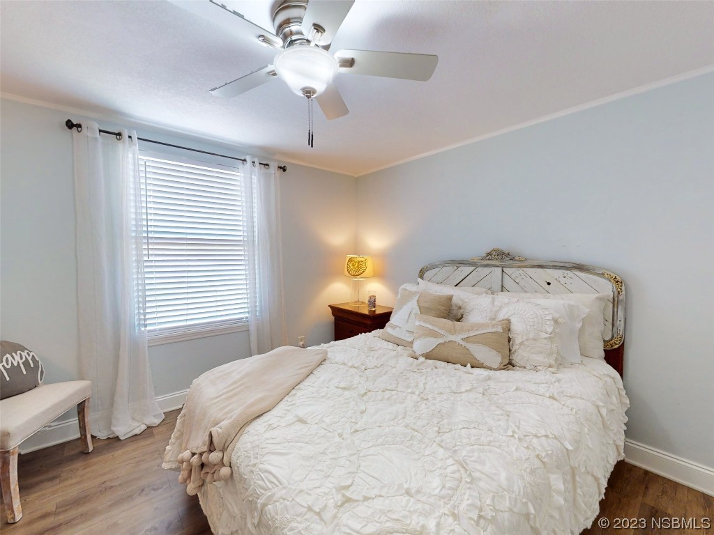 69 Sabal Cay Court, Unit 690 New Smyrna Beach, FL 32169 - Photo 9 of 30 a bedroom with a bed and wooden floor