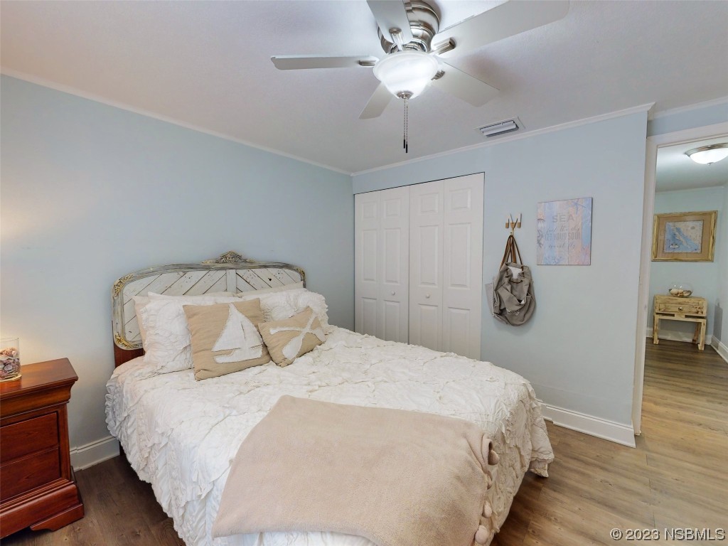 69 Sabal Cay Court, Unit 690 New Smyrna Beach, FL 32169 - Photo 10 of 30 a bedroom with a bed and a chandelier