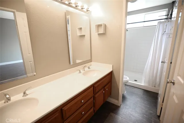 a bathroom with a double vanity sink and mirror with shower