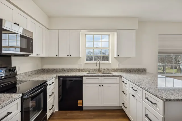 a kitchen with stainless steel appliances granite countertop a sink stove and cabinets