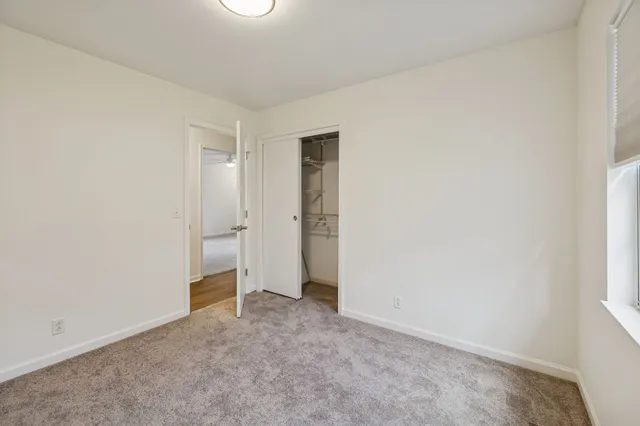 a bathroom with a granite countertop toilet sink and mirror