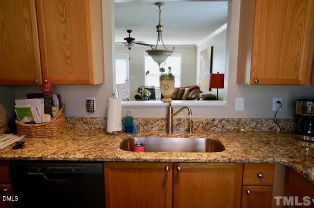 a kitchen with kitchen island granite countertop a sink a counter top space and cabinets