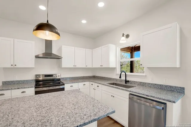 a kitchen with a sink a stove and cabinets
