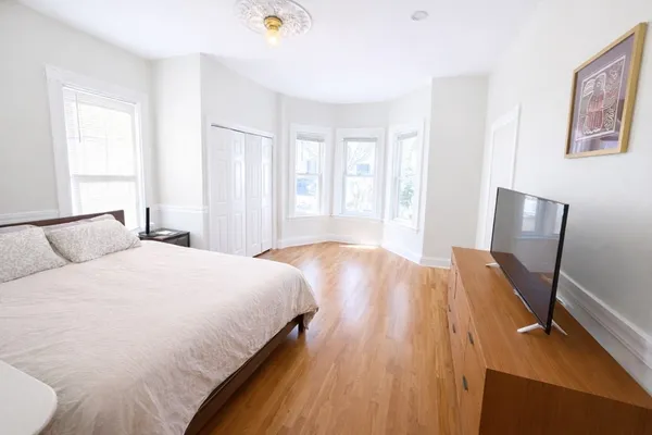a bedroom with a bed and wooden floor