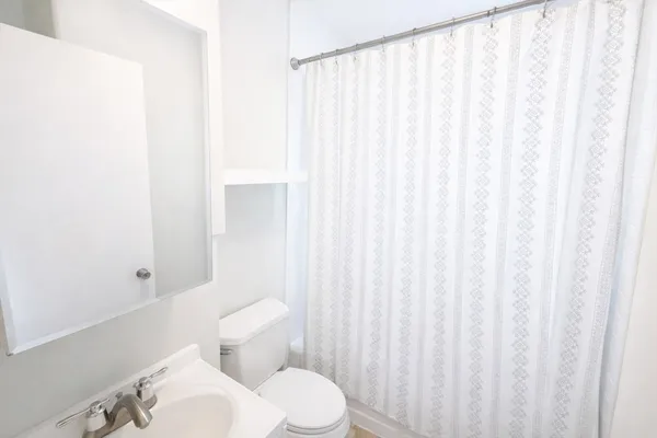 a white toilet sitting next to a shower curtain