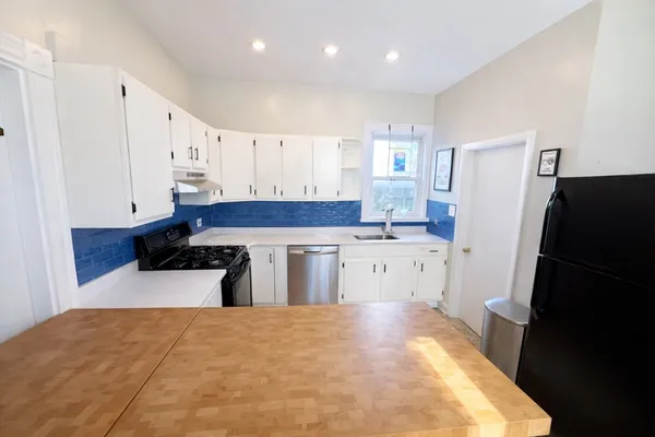 a large kitchen with a refrigerator and a stove
