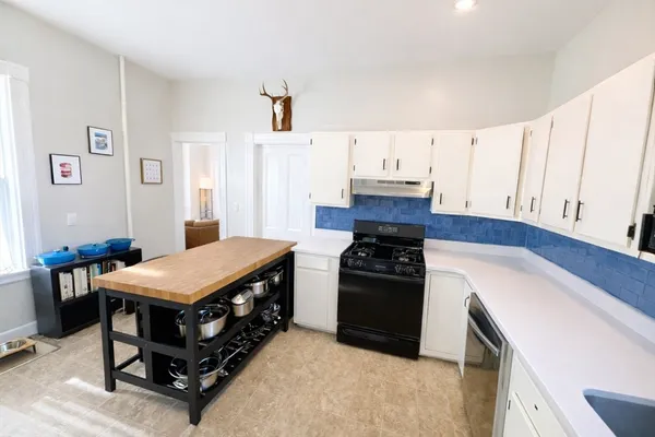 a kitchen with stainless steel appliances stove top oven and cabinets